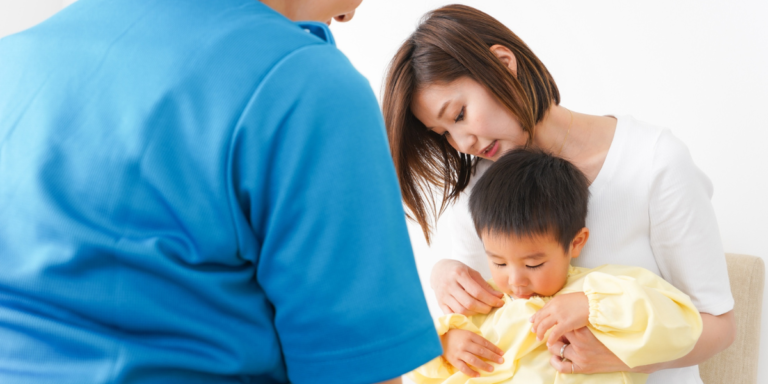 A woman and a child sit together on a couch, engaged in a nurturing and supportive moment.