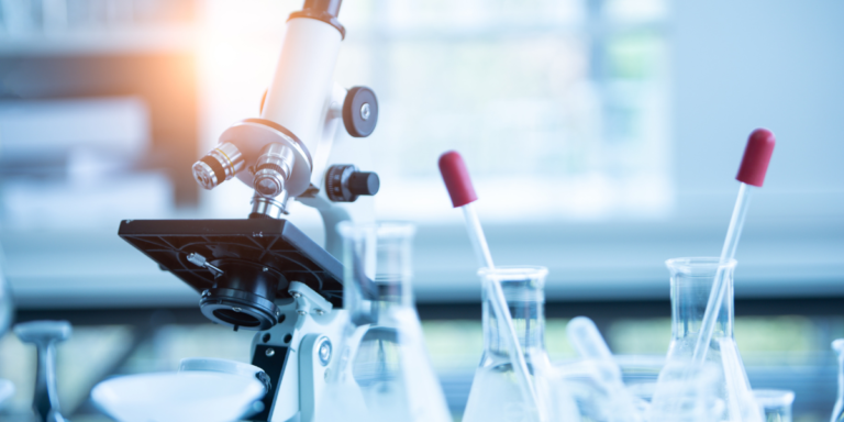 Microscope and test tubes on a lab bench, representing medical and diagnostic training in healthcare programs.